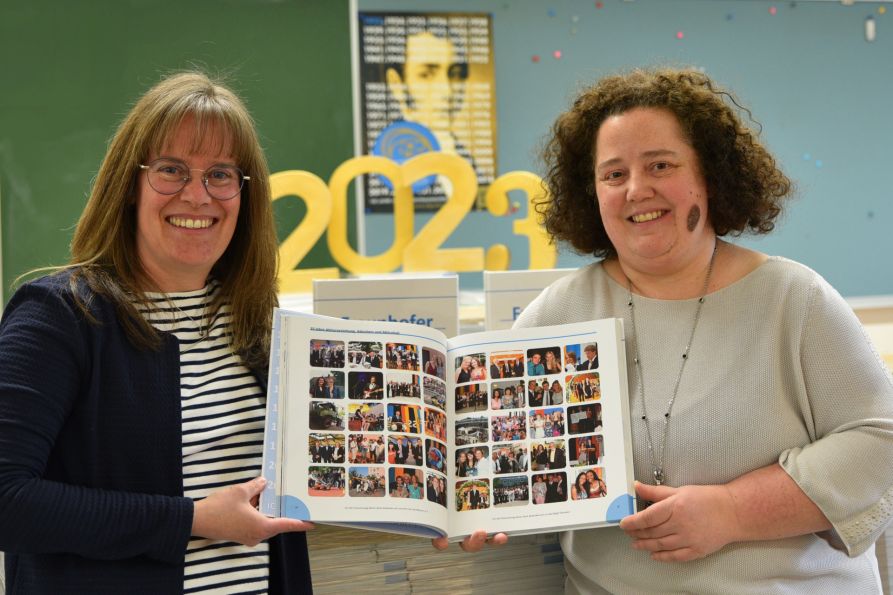 StDin Susanne Melichar vom Fraunhofer-Gymnasium und Barbara Bucher von der Druckerei Vögel freuen sich über die gelungene Festschrift zum 100-jährigen Jubiläum.